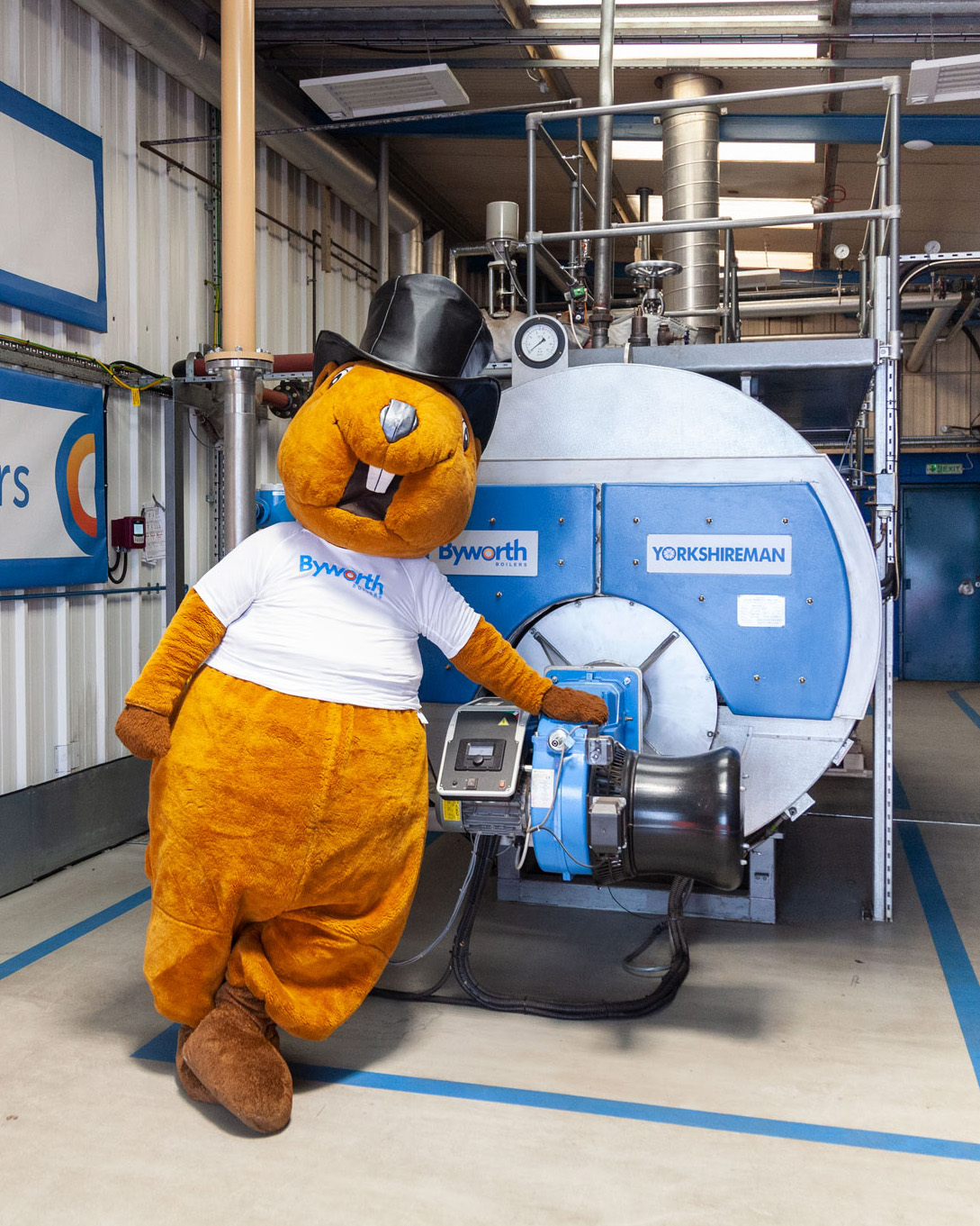 A mascot in a beaver costume stood in a boiler house 